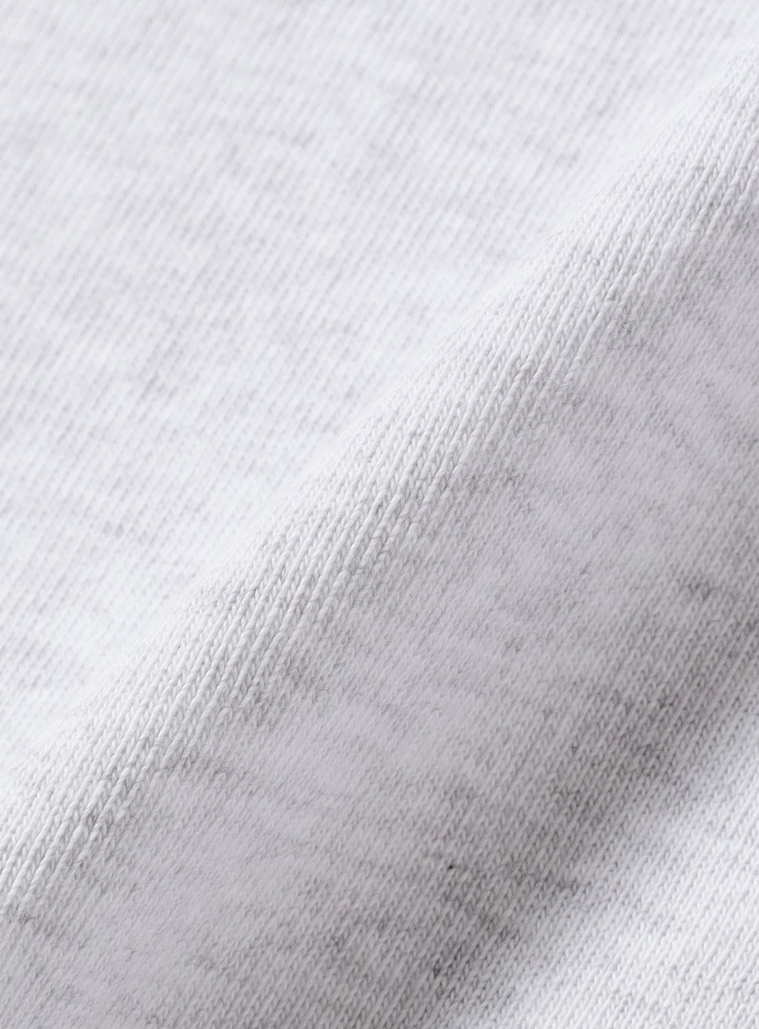 Close-up of a light gray, soft knit fabric, slightly folded to reveal texture and weave—part of the BEAMS T 50th Anniversary x KOICHI YAIRI Graphic T-Shirt.