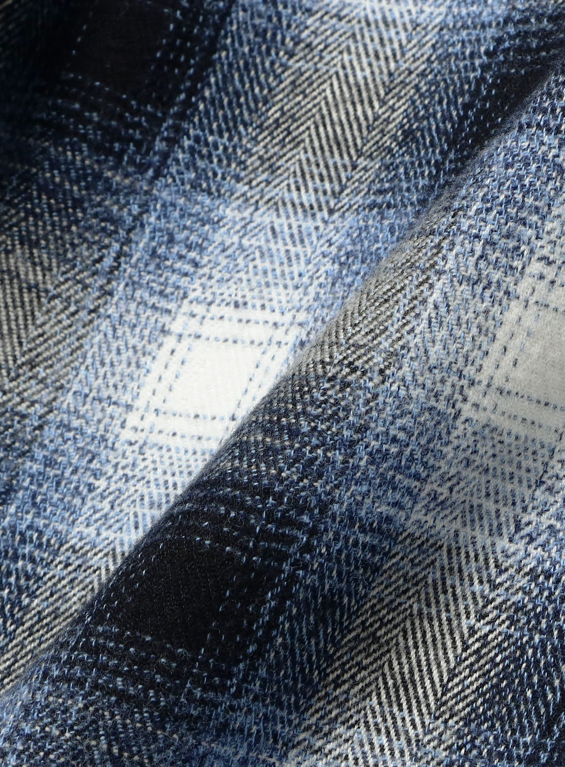 Close-up of Check Shorts in a blue, grey, and white ombre check fabric with a herringbone weave.