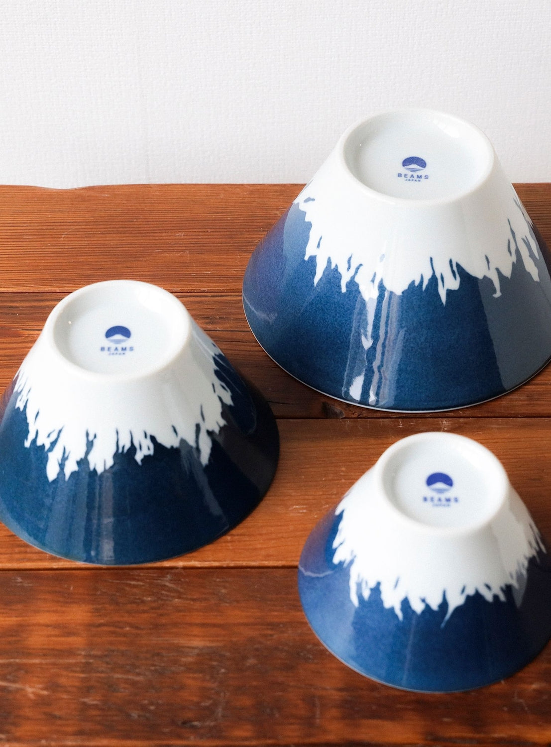 Three blue ceramic bowls with white mountain designs on a wooden surface.