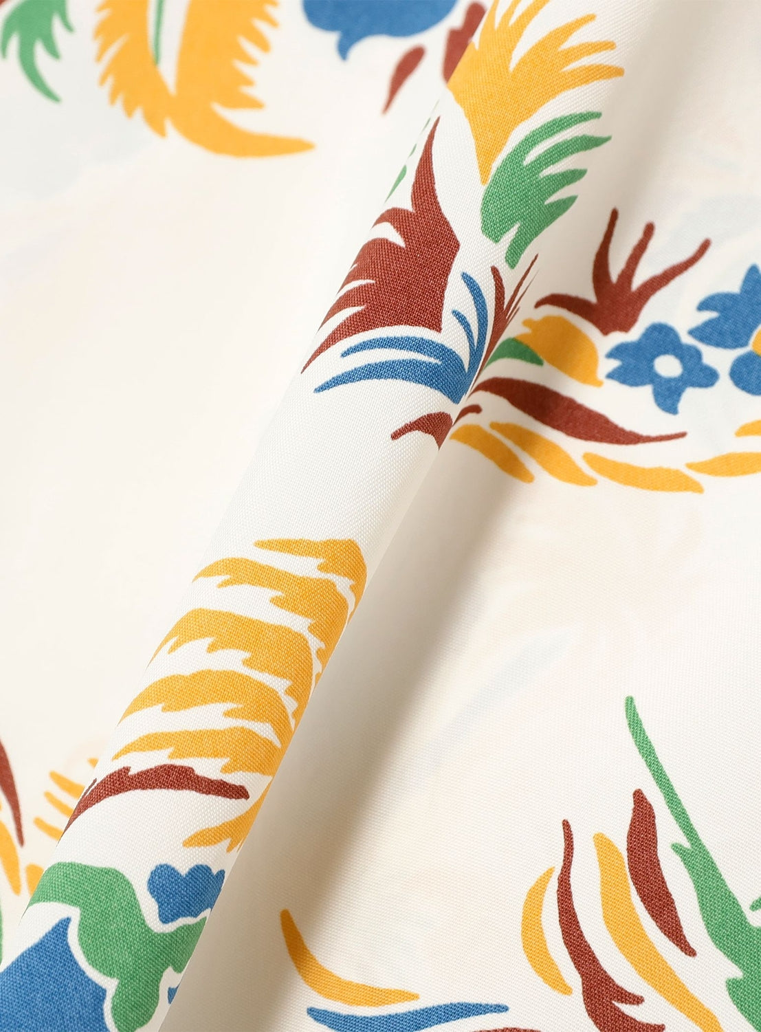 Close-up of the [Exclusive] SUN SURF x BEAMS BOY Open Collar Shirt by SUN SURF, featuring a vibrant vintage-inspired floral print in yellow, green, blue, and brown on white fabric with a classic Hawaiian texture and drape.
