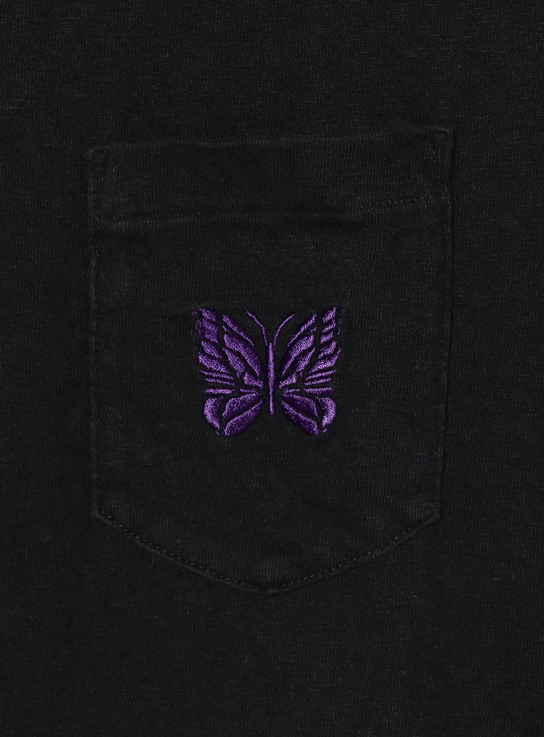 Black shirt with a purple embroidered butterfly on the chest pocket
