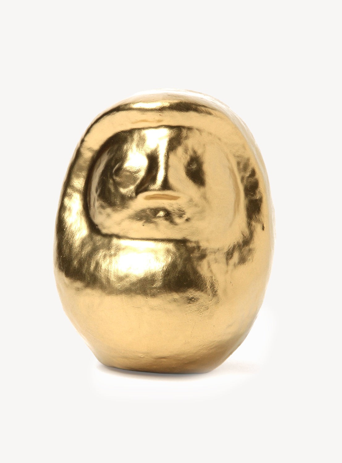 Gold-colored daruma on a white background