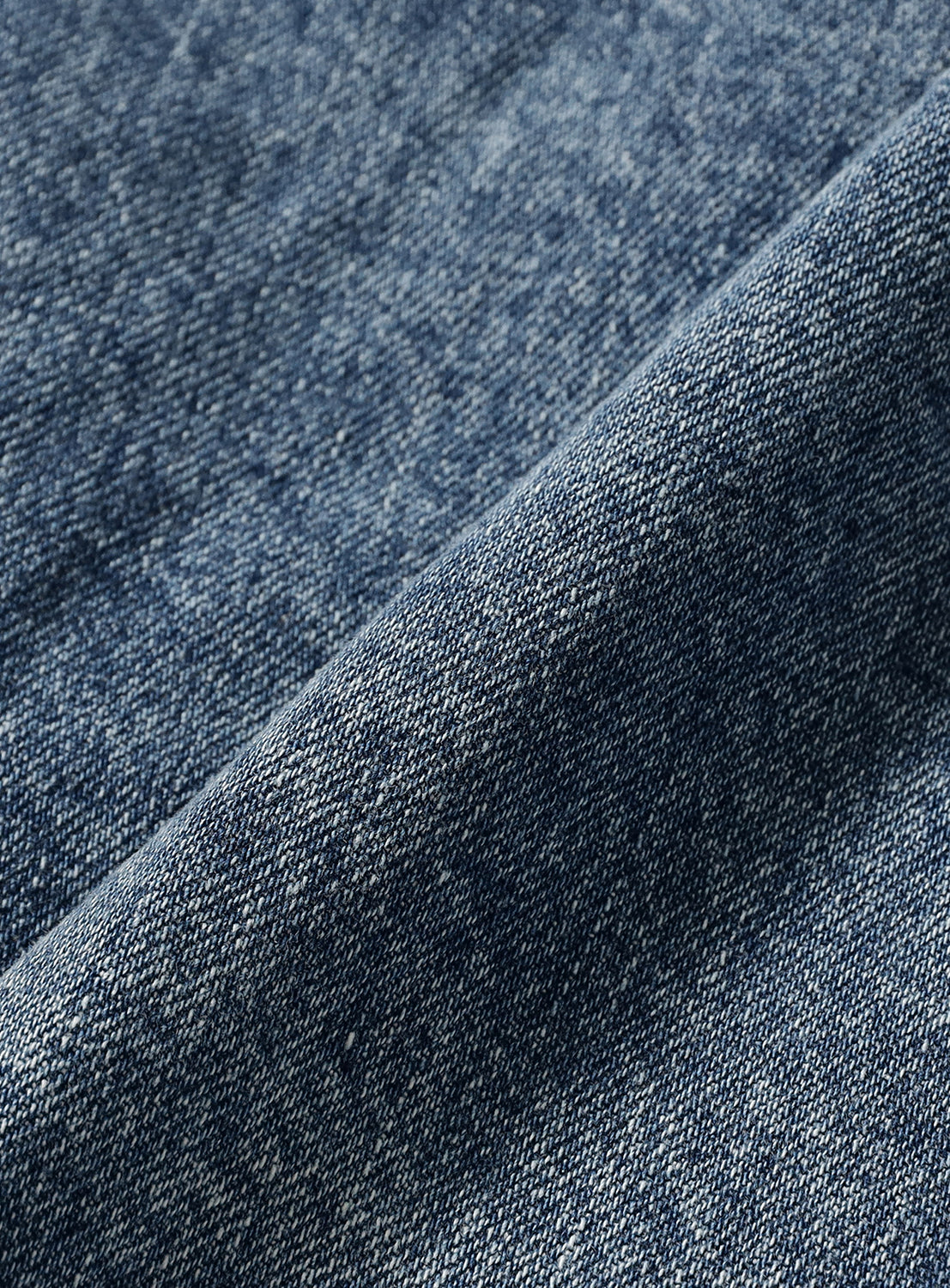 Close-up of the folded Japanese denim fabric of a BEAMS Hooded Trucker Denim Jacket.
