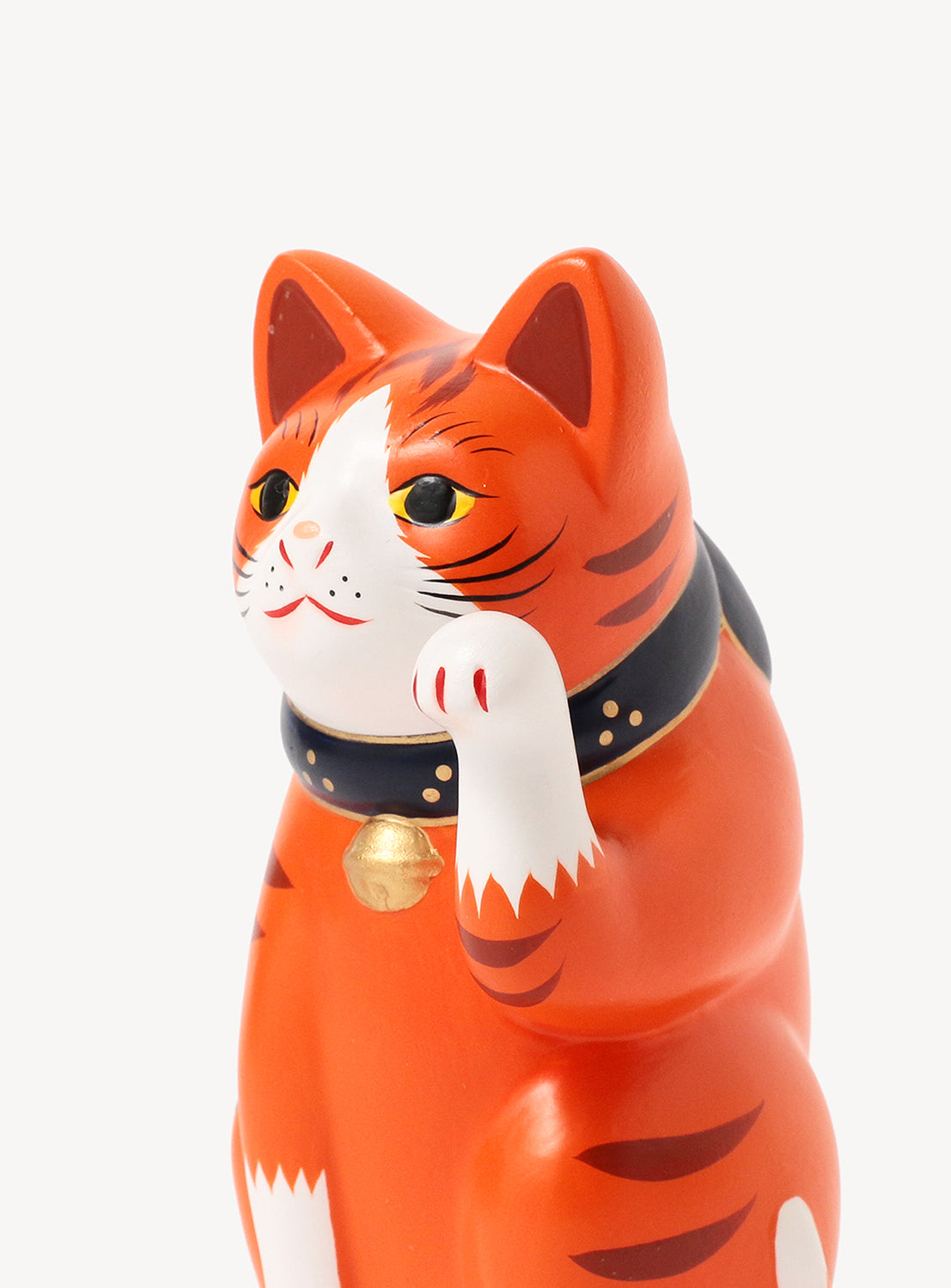Red cat figurine with a bell on a white background