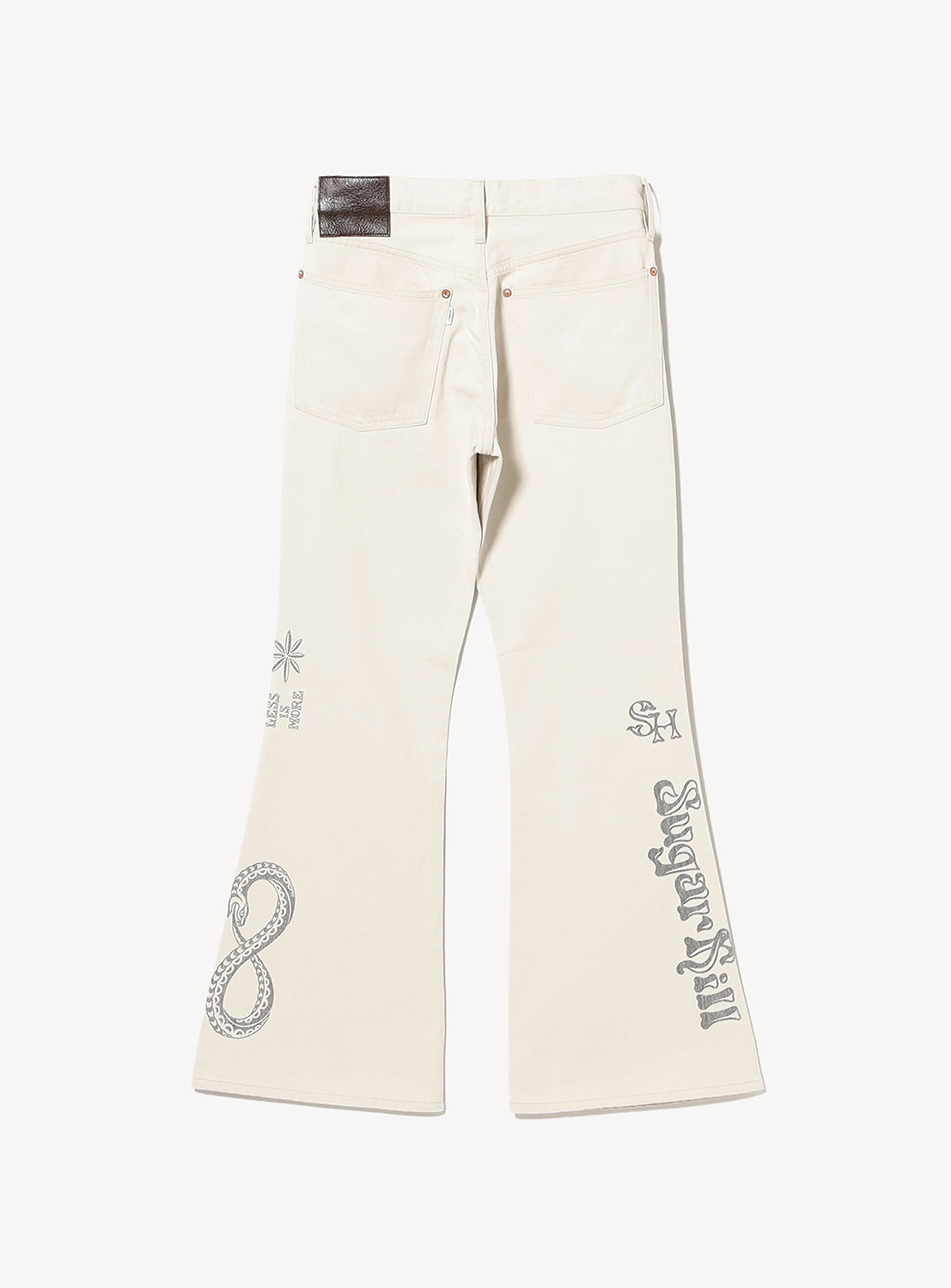 SUGARHILL's Tattoo Flash Print Modern Denim Flared Cut features off-white premium Okayama denim with gray tattoo-inspired artwork, including a snake, numbers, symbols, and bold text on the legs and back pocket.
