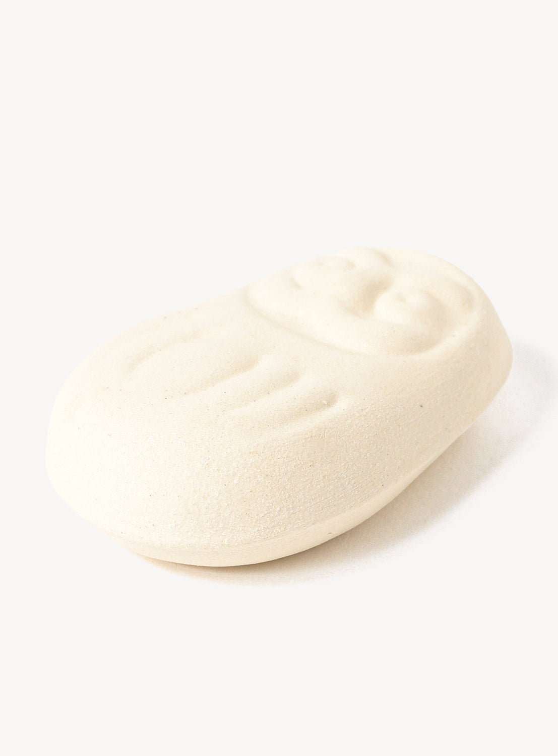 White daruma chopstick rest on a white background
