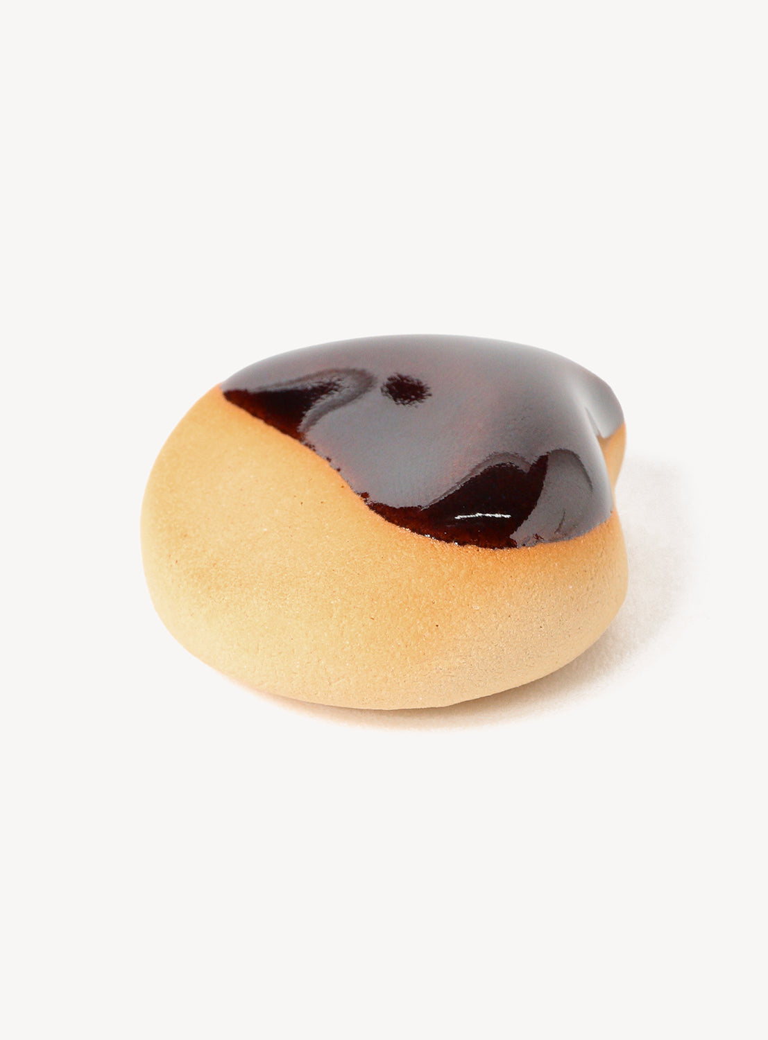 Heart-shaped cookie chopstick rest with chocolate glaze on a white background