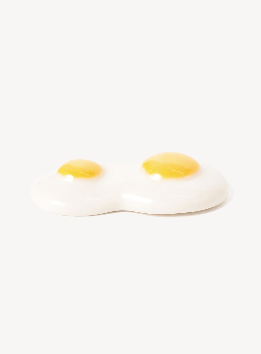 Two sunny-side-up eggs chopstick rest on a white background