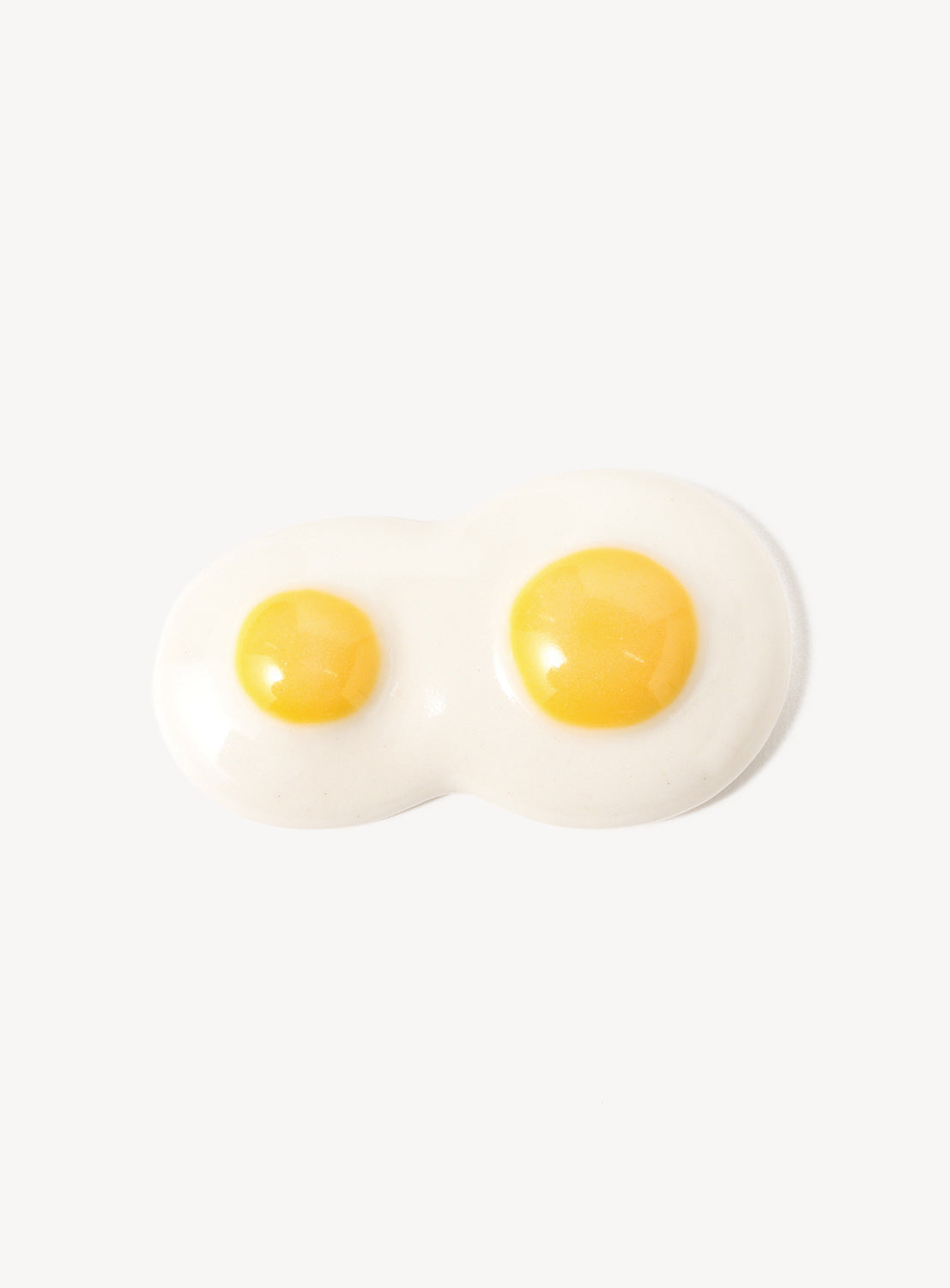 Two sunny-side-up eggs chopstick rest on a white background