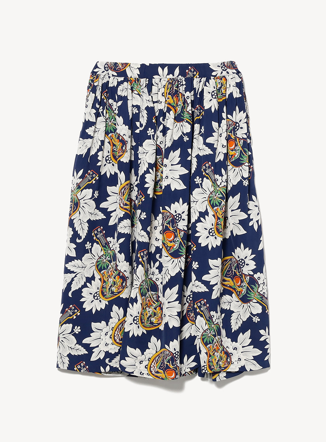 The [Exclusive] SUN SURF x BEAMS BOY Aloha Gathered Long Skirt by SUN SURF features navy fabric with bold floral and fruit prints, an elastic waistband, and a full gathered silhouette inspired by vintage Hawaiian style.