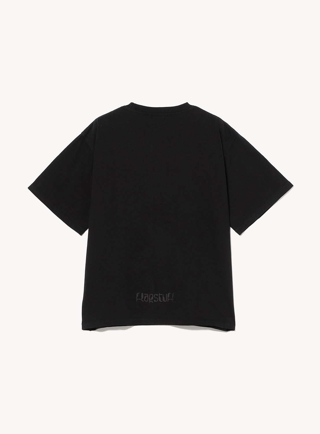 The F-LAGSTUF-F Symbol Logo Tee is a heavyweight black cotton T-shirt shown from the back on a white background, featuring "F-LAGSTUF-F." subtly printed near the bottom hem.