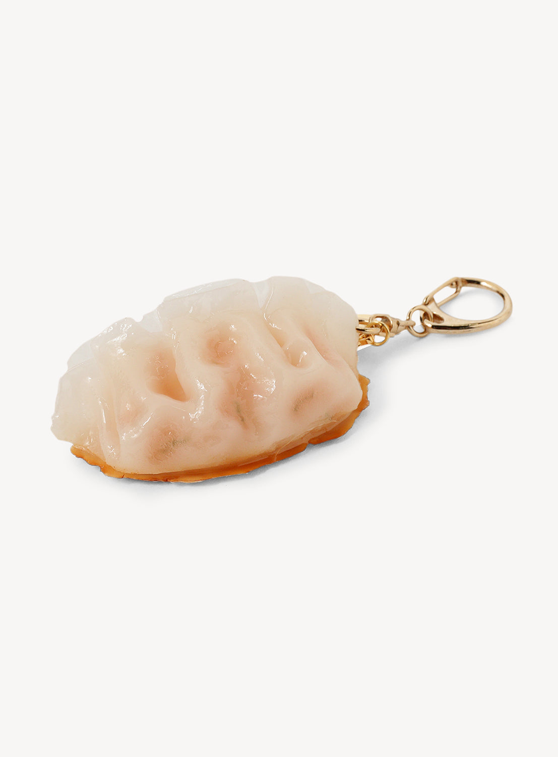 Gyoza-shaped keychain with gold clasp on a white background