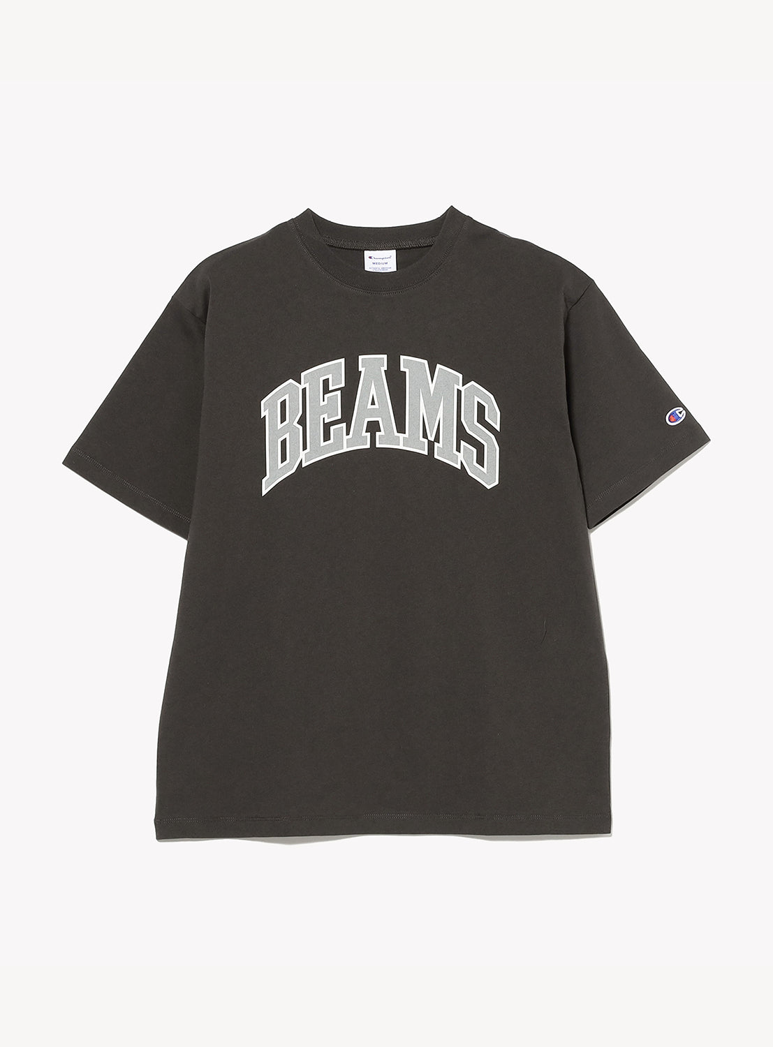 The [Exclusive] BEAMS x Champion Logo T-Shirt by CHAMPION is a black short-sleeve tee showcasing "BEAMS" in large, bold white lettering across the chest and finished with a small BEAMS logo patch on the left sleeve. Made from sustainable American cotton, it offers both comfort and eco-conscious style.