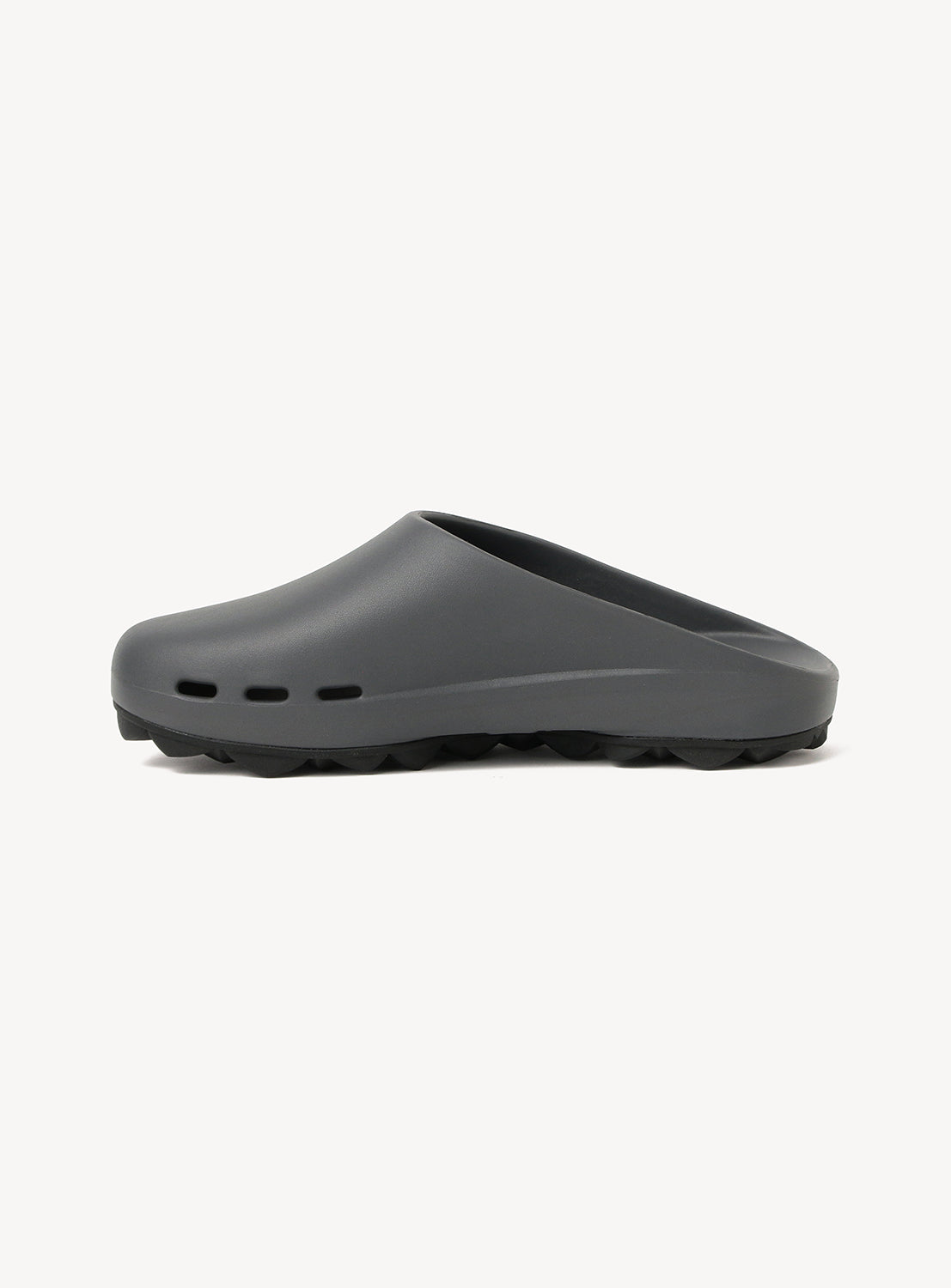 The PPACO LUX-1 Closed-Toe Slide Sandal is shown in dark gray with three small ventilation holes near the sole, cushioned comfort, and a lightly textured black sole, displayed against a plain white background.