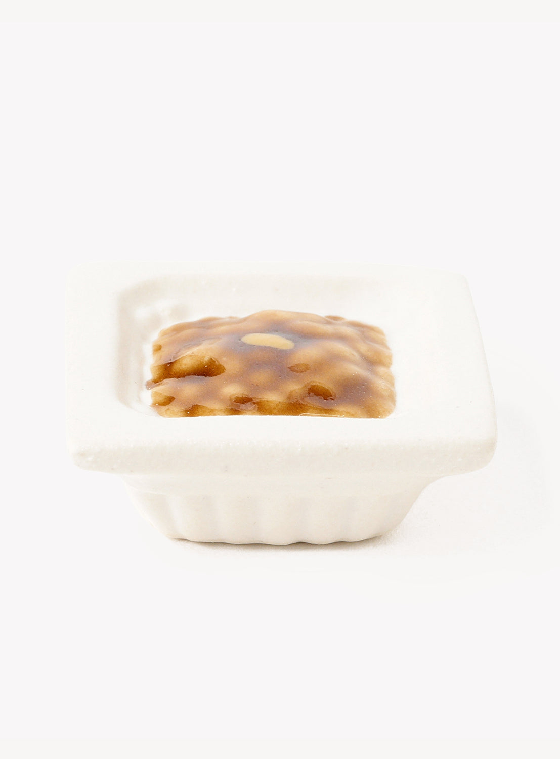 Small dish of food chopstick rest on a white background