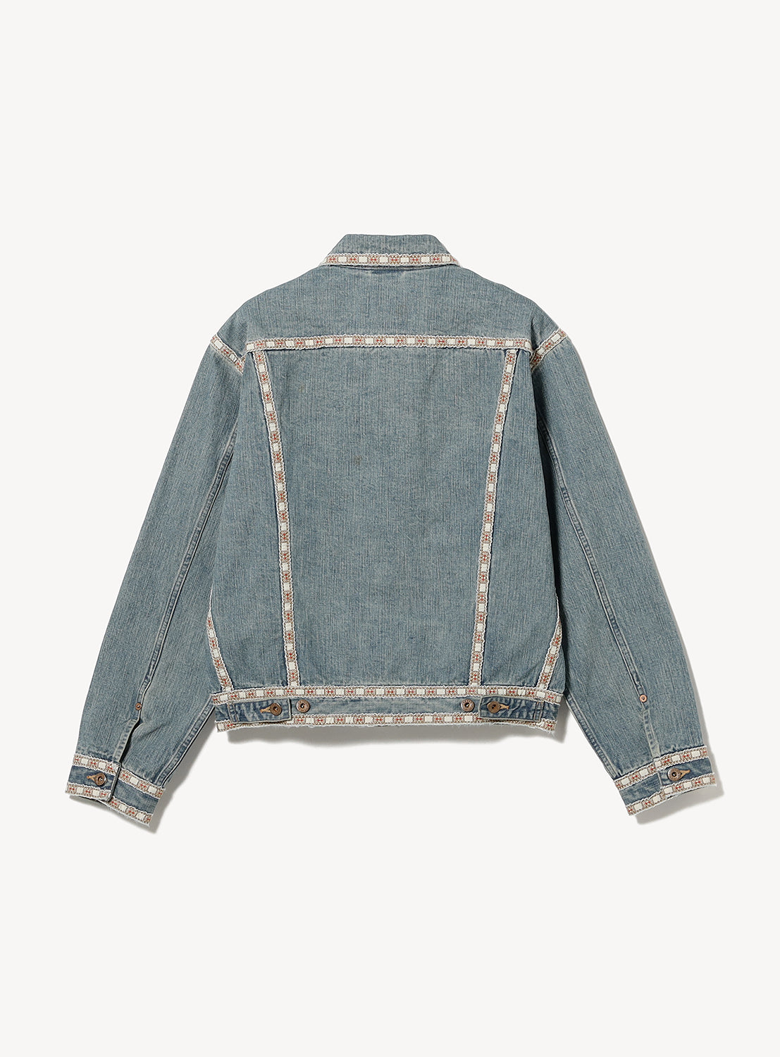 The SUGARHILL Faded Tyrol Denim Jacket is displayed from the back in a vintage blue wash, with Tyrolean detailing along seams, collar, cuffs, and hem. Features buttoned cuffs and waistband adjusters for a classic finish.