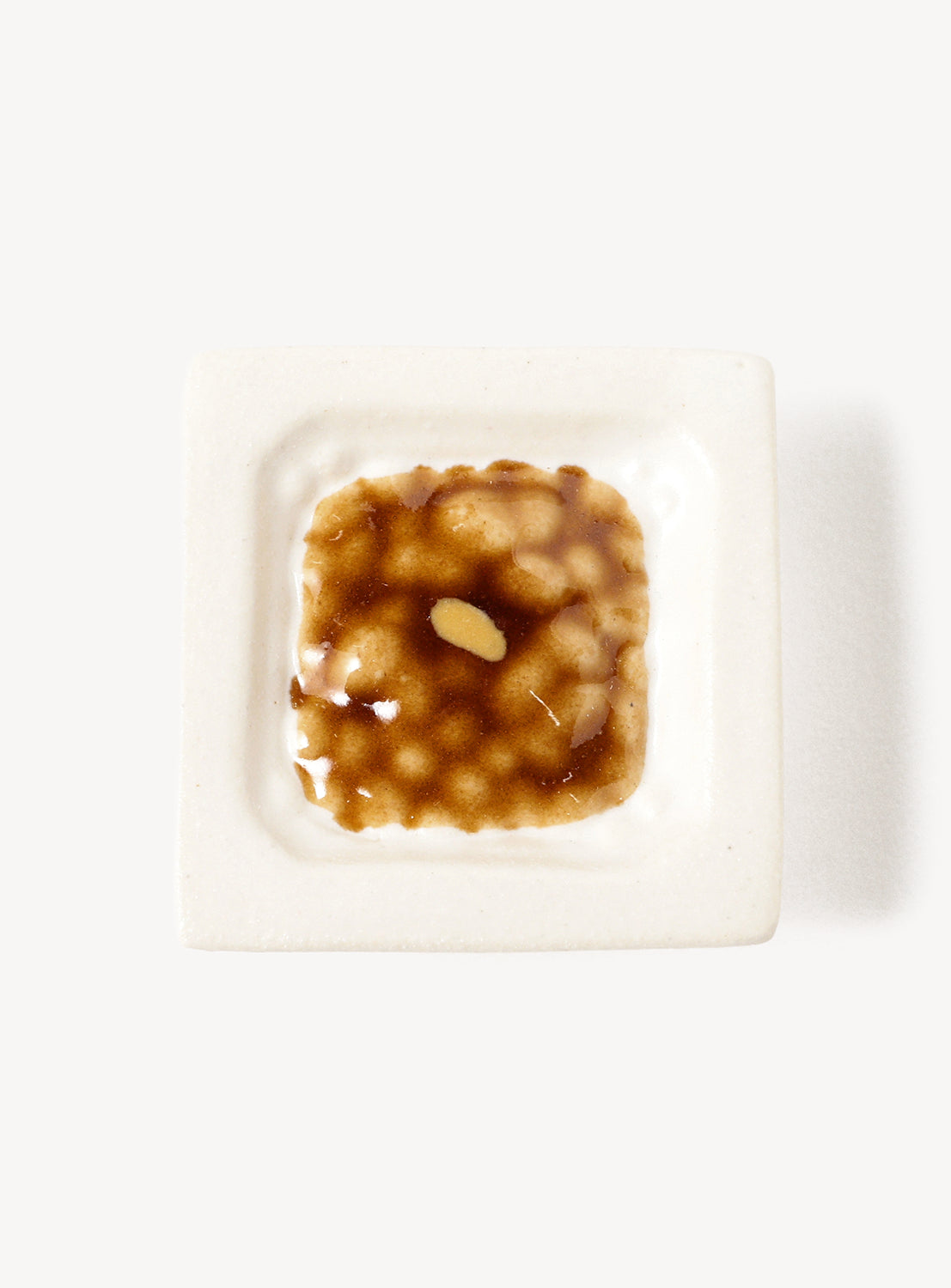Small dish of food chopstick rest on a white background