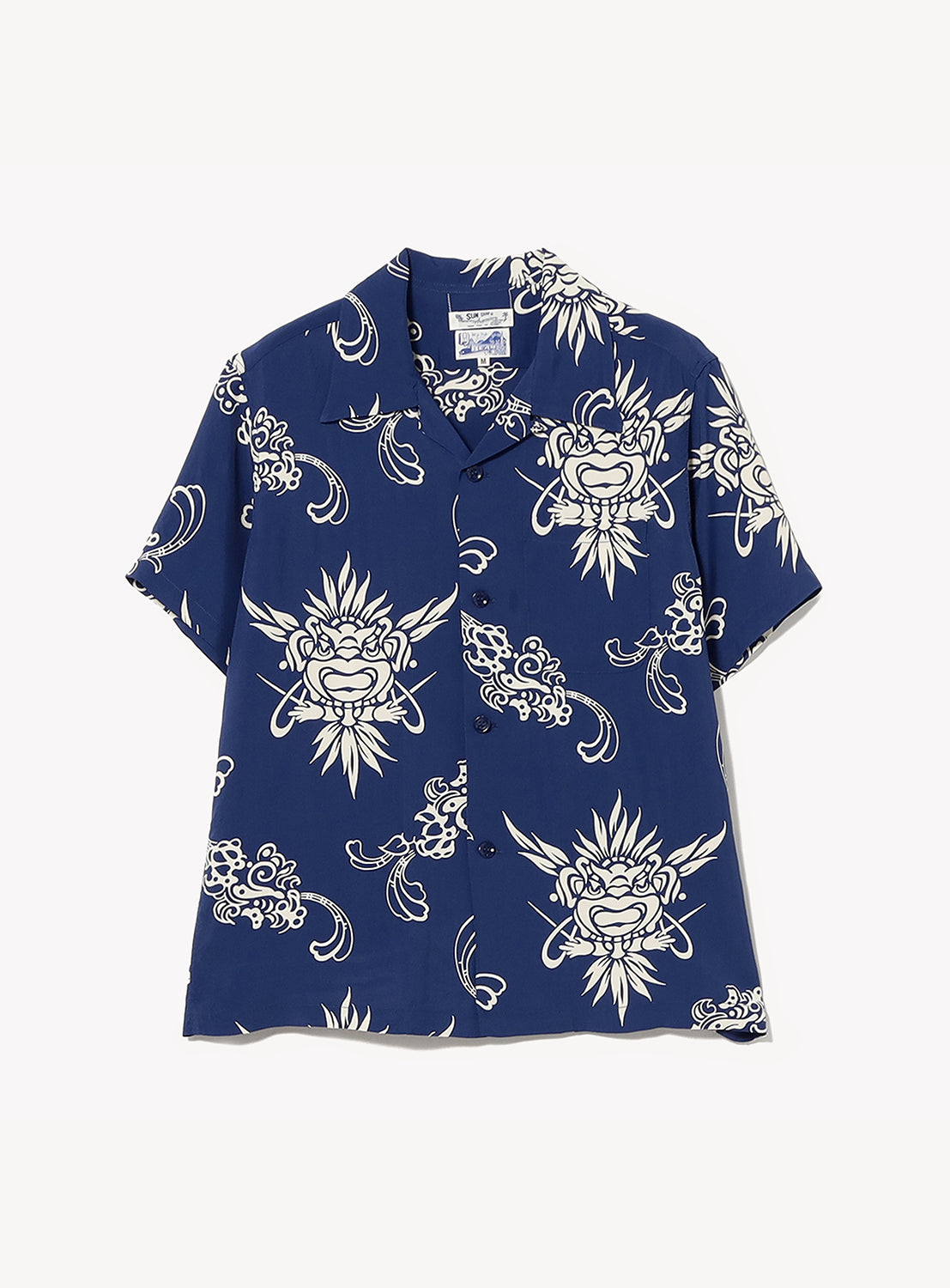 The [Exclusive] SUN SURF x BEAMS BOY Open Collar Shirt by SUN SURF is a Hawaiian-inspired, short-sleeve button-up with a dark blue base and white abstract floral and face-like patterns, shown flat on a light backdrop.