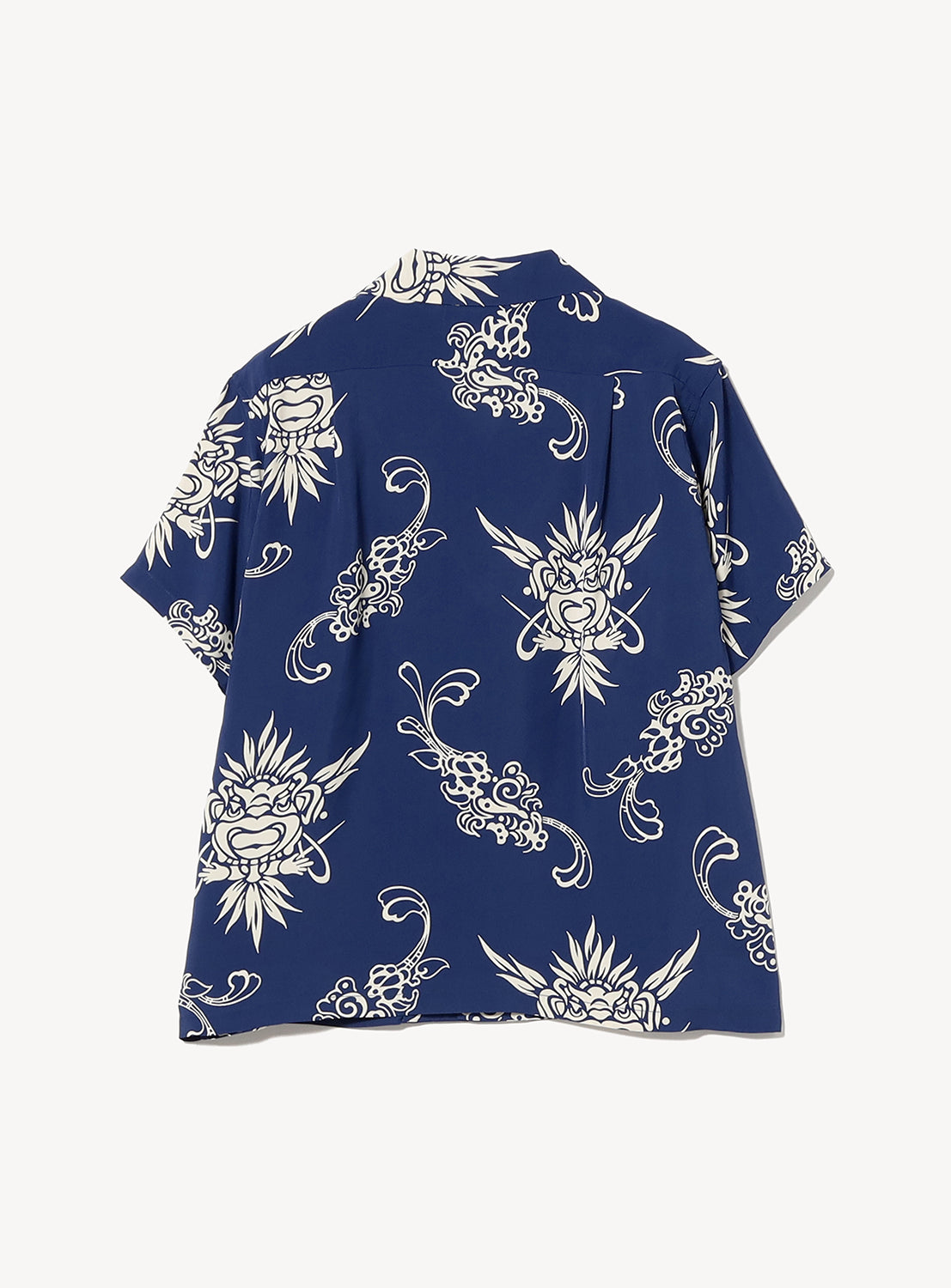 The [Exclusive] SUN SURF x BEAMS BOY Open Collar Shirt by SUN SURF is a navy Hawaiian-style short-sleeve button-up with a white abstract pattern of stylized faces and swirls, shown flat with the back visible.