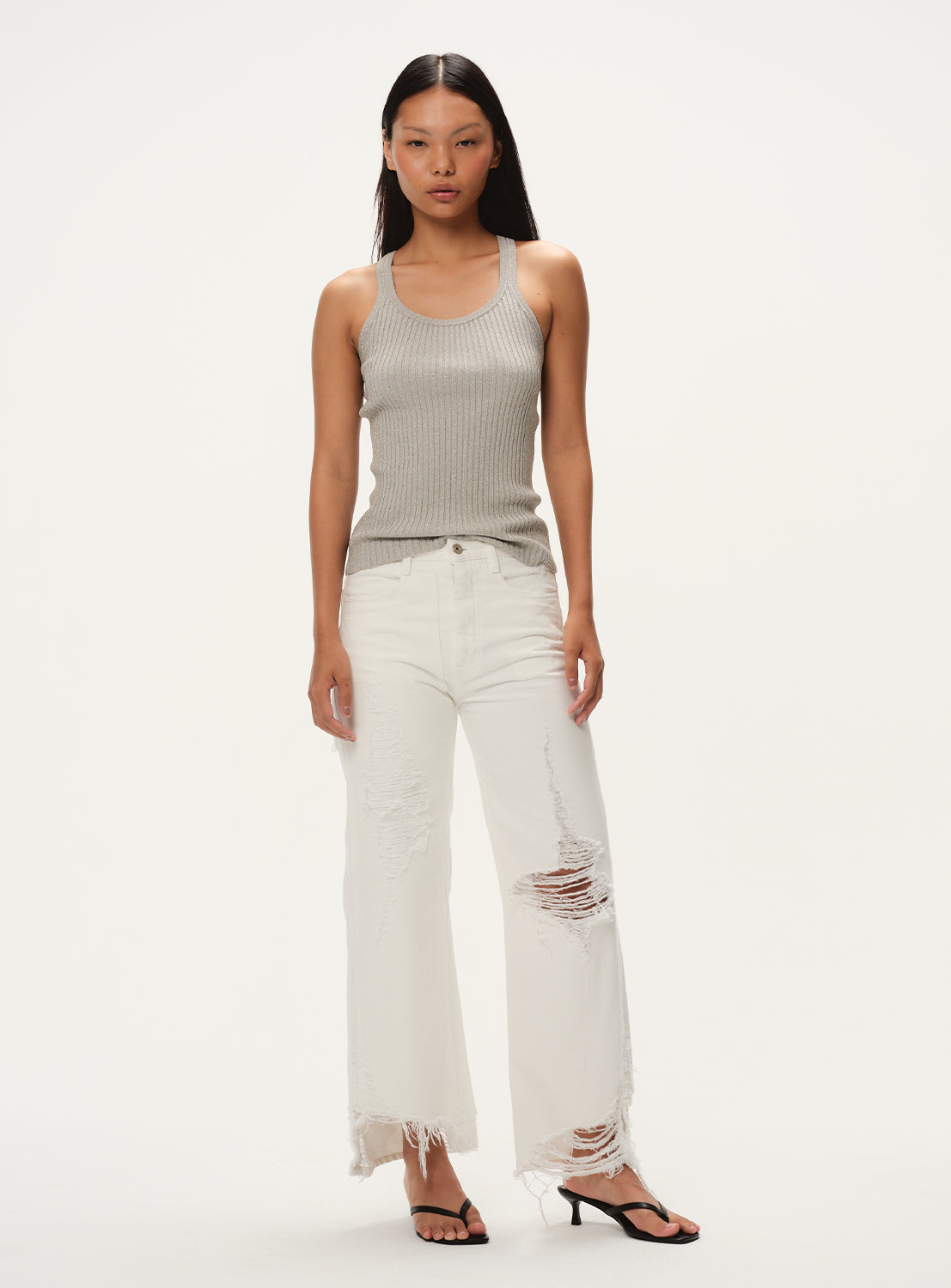 Full body image of a model wearing a ribbed grey glitter tank top. 