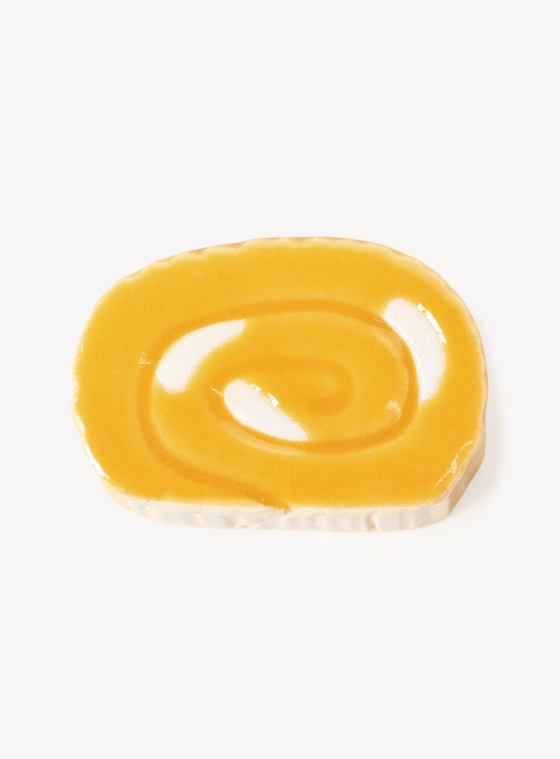 Yellow ceramic chopstick rest on a white background