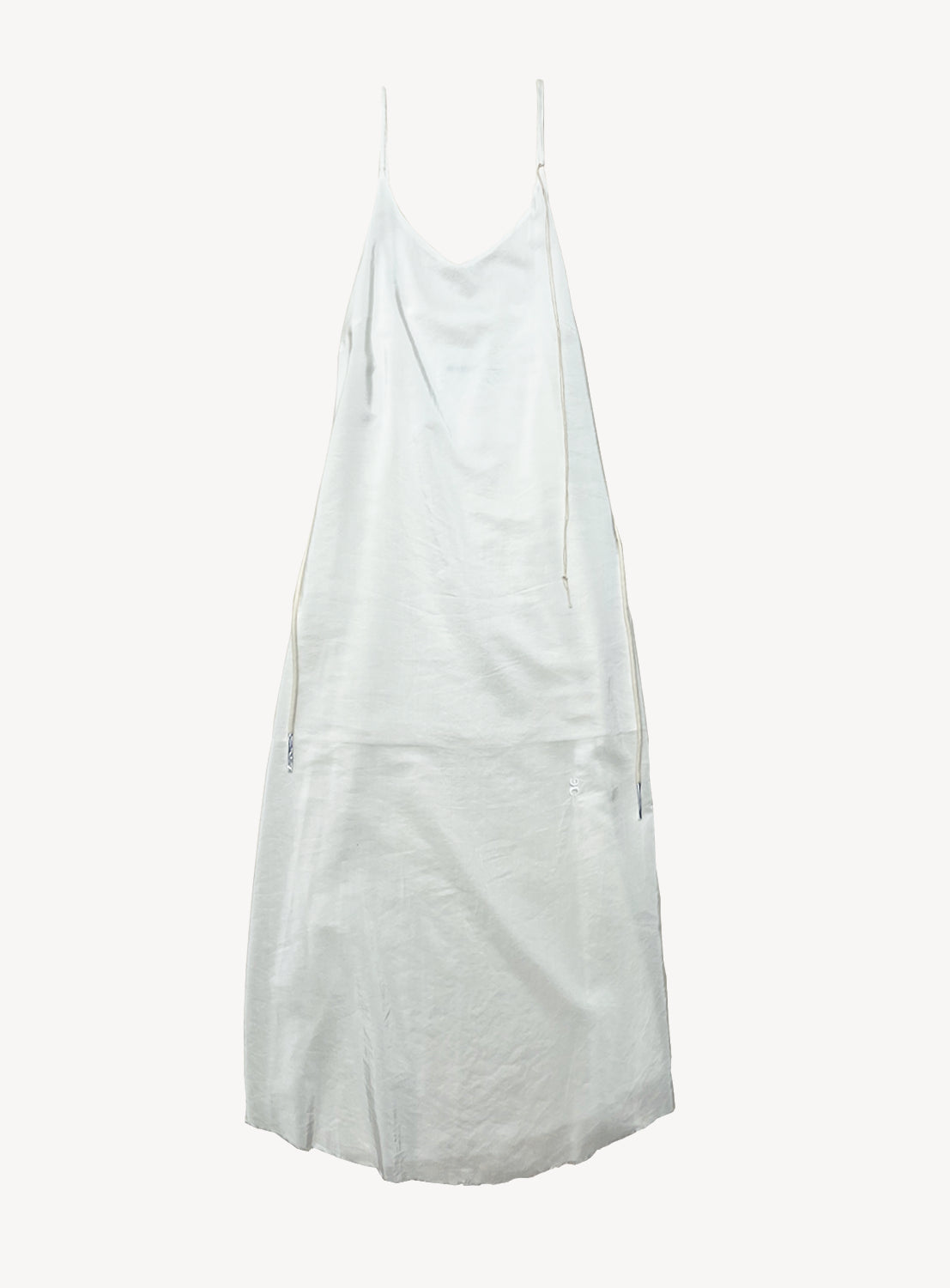 The Duchesse Sleep Dress by VIAPIAVE33 is a plain white sleeveless slip dress with a fluid silhouette, featuring thin adjustable shoulder straps and a loose, minimalist design displayed against a white background.