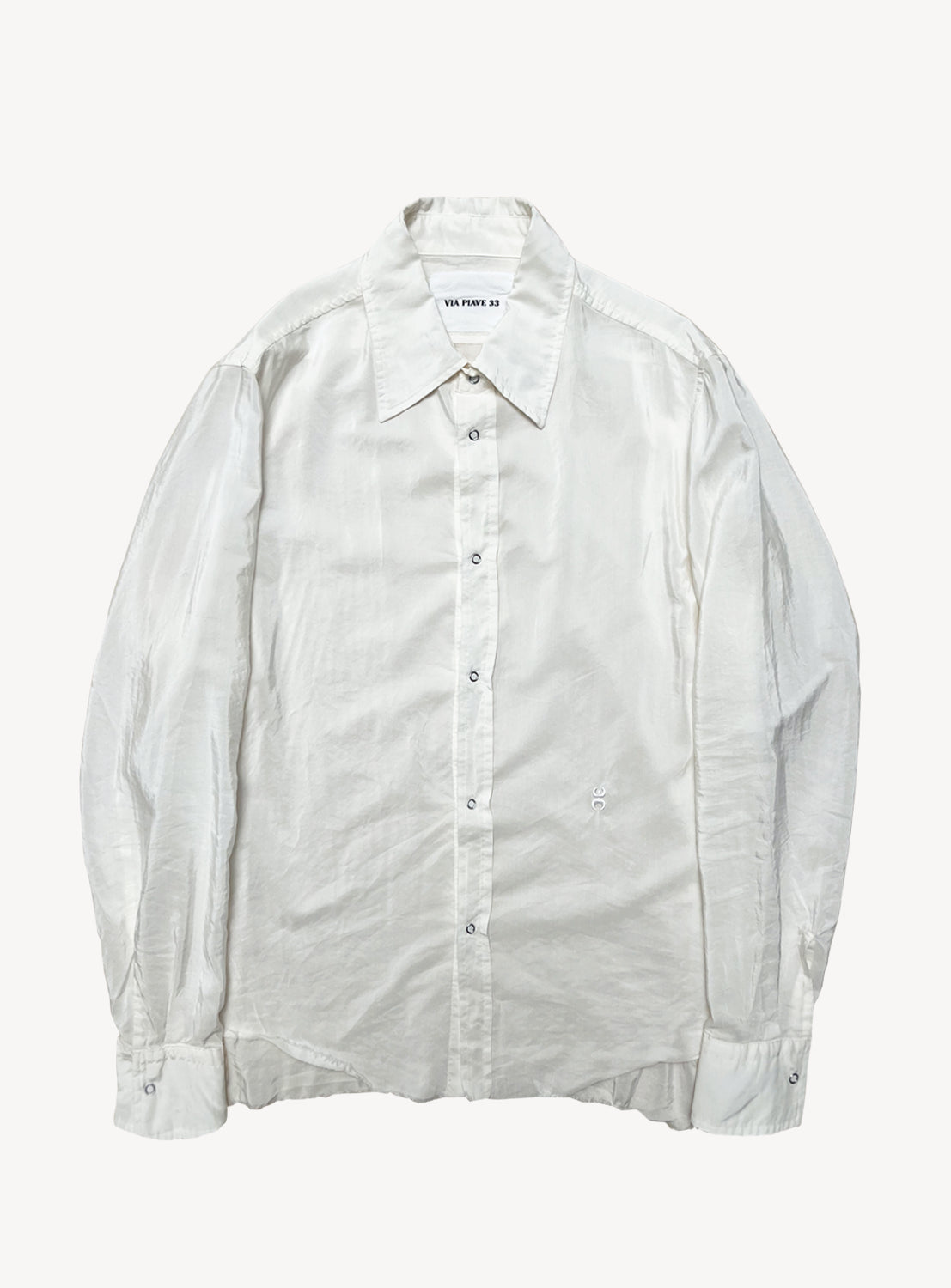 The Duchesse Shirt by VIAPIAVE33 is a long-sleeve, button-up white shirt with a classic collar, shown laid flat on a white background. Made from lightweight fabric, it features a slightly wrinkled texture and visible buttons down the front, offering a relaxed fit designed for everyday comfort.